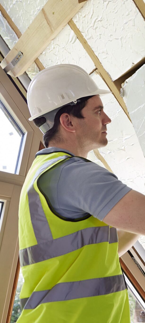 Isolation du toit par l'intérieur, artisan installant un isolant phonique et thermique dans des combles aménagés Isolation du toit par l'intérieur, artisan installant un isolant phonique et thermique dans des combles aménagés